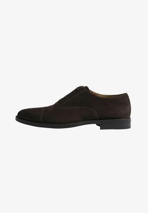 Zapato oxford de ante marrón con una superficie lisa, punta redondeada y cinco ojales de metal para los cordones. Suela de goma resistente.