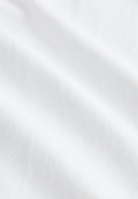 Tessuto bianco con una texture liscia, che mostra sottili motivi a coste. Il materiale appare leggero e leggermente riflettente.