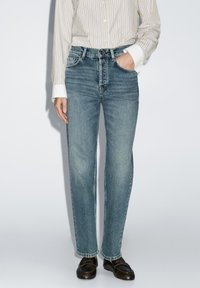 Blaue Denim-Jeans mit geradem Schnitt, heller Waschung und leichtem Verblassen. Verfügt über ein klassisches Fünf-Taschen-Design und einen traditionellen Knopfverschluss.