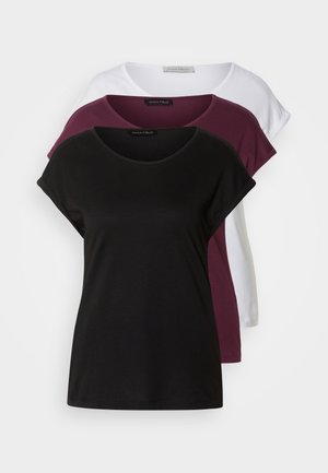 Trois t-shirts : un noir, un bordeaux, un blanc. Chacun possède un col rond, des manches courtes et une texture en coton doux. Étiquettes visibles.