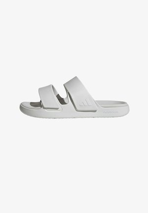 White sandals made of molded foam with two wide straps, a contoured footbed, and a textured outsole featuring a subtle logo detail.