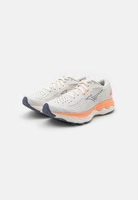 Chaussures de sport avec une tige en mesh gris clair respirant, des accents corail et une semelle texturée présentant un motif de bande de roulement bleu foncé.
