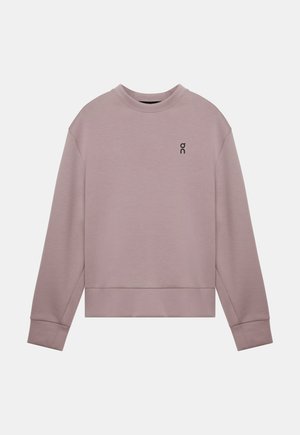 Sweat-shirt violet clair en tissu doux, avec un col rond, épaules tombantes et un petit logo noir sur le côté gauche de la poitrine.