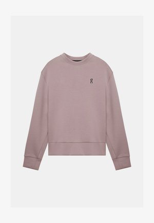 Sweat-shirt violet clair en tissu doux, avec un col rond, épaules tombantes et un petit logo noir sur le côté gauche de la poitrine.