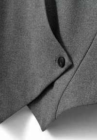 Gray textured fabric with a smooth finish, featuring a visible black button and angular, overlapping design elements.