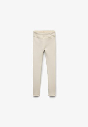 Leggings beiges en matière douce et extensible. Dotés d'une taille large et d'un design lisse sans couture pour plus de confort.