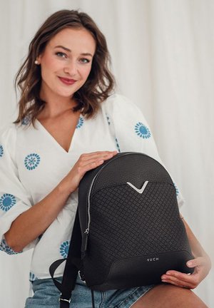Black textured backpack with a geometric pattern, silver zipper, and a prominent V-shaped logo. Made of durable material, modern design.