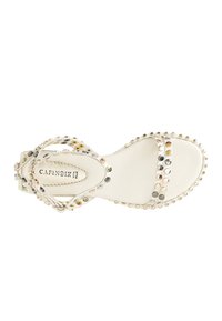 Sandal in pelle bianca con cinturini incrociati decorati con borchie metalliche in oro, argento e tonalità rosa, dotata di suola imbottita.