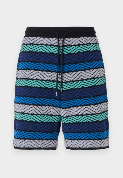 Mehrfarbige Shorts mit einem Zickzackmuster in Blau-, Grün- und Grautönen. Mit einem schwarzen Bund und Kordelzug.