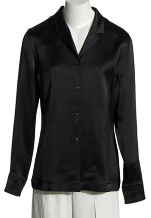 Blouse en satin noire à manches longues avec col et boutons sur le devant, présentée sur un buste de mannequin blanc.