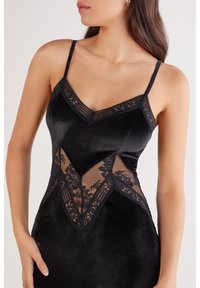 Czarna sukienka z satyny o dopasowanym kroju, z panelami z koronki oraz regulowanymi ramiączkami typu spaghetti z ozdobną lamówką przy dekolcie.