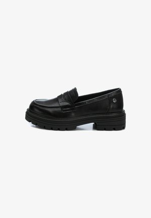Mocasines de cuero negro con un diseño estructurado y bajo, que cuentan con una correa decorativa, suela de goma gruesa y superficies texturizadas.