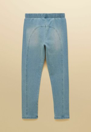 Lyseblå elastiske bukser med elastik i taljen og buet sømdetalje på bagsiden, lagt fladt på en beige baggrund.