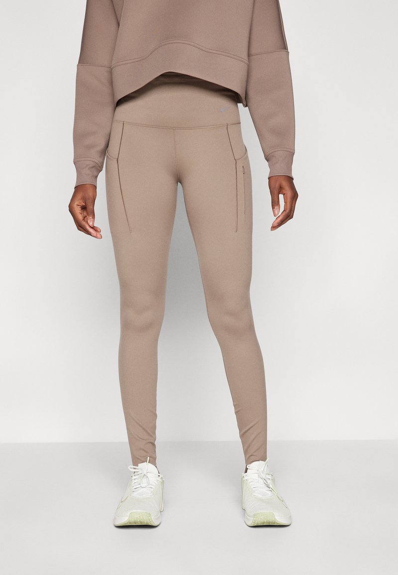 Leggings a vita alta in tessuto stretch color marrone chiaro con cuciture piatte e due tasche laterali. Abbinati a una felpa cropped coordinata.