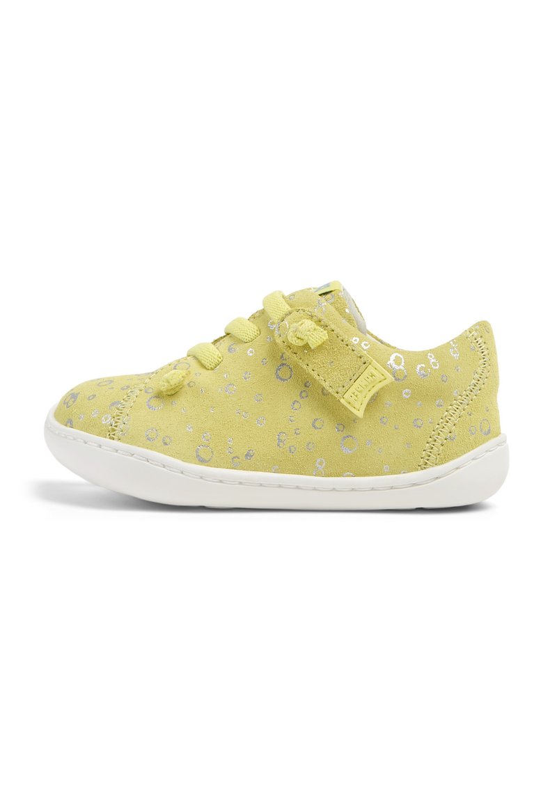 Sneaker giallo in suede con motivi circolari silver, texture morbida, lacci e suola in gomma bianca per ammortizzazione e grip.