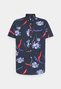 Camisa de manga corta en tejido azul marino con un patrón floral en blanco, rojo y azul, con cierre de botones y cuello clásico.