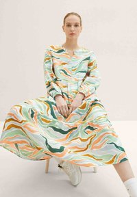Langes Knopfkleid aus gemustertem Stoff mit Wellen in Mintgrün, Pfirsich und erdigen Tönen. Texturiert, lockere Passform mit langen Ärmeln.