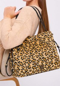 Borsa a tracolla con stampa leopardata, superficie testurizzata color tan, dettagli neri, due spallacci e un'etichetta del logo sulla parte anteriore.