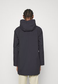 Laivaston vedenpitävä parka, jossa on suuri huppu, pitkät hihat ja hieman kapeneva malli. Ominaisuuksiin kuuluu sileä pinta ja minimalistinen muotoilu.