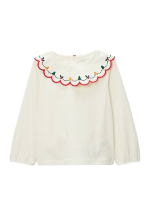 Chemise blanche à manches longues avec un col rouge festonné, décorée de broderies vertes et jaunes représentant des arbres et des personnages en pain d'épice.