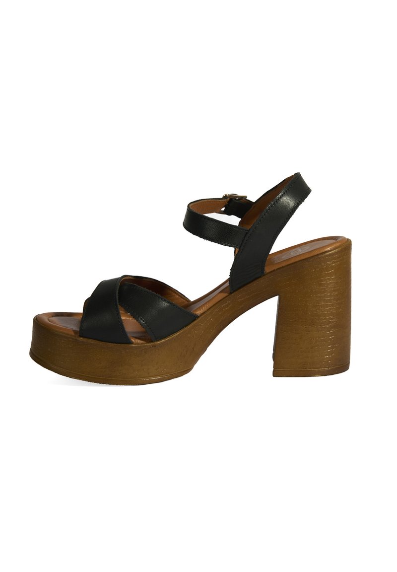 Schwarze Leder High Heels Sandalen mit breiter Plattform und dicker Ferse, ausgestattet mit einem Kreuzriemen-Design und einer Schnallenverschluss.