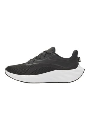 Zapatilla deportiva negra con parte superior de tela acanalada, cordones negros y suela acolchada blanca y gruesa, mostrada de lado sobre un fondo blanco.