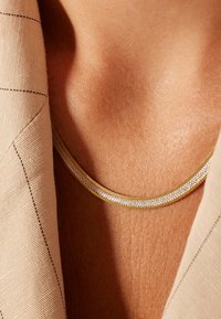 Gouden en zilveren metalen ketting met een dubbellaags ontwerp. Kenmerkt een soepele, glanzende textuur en nauwkeurige details langs de randen.