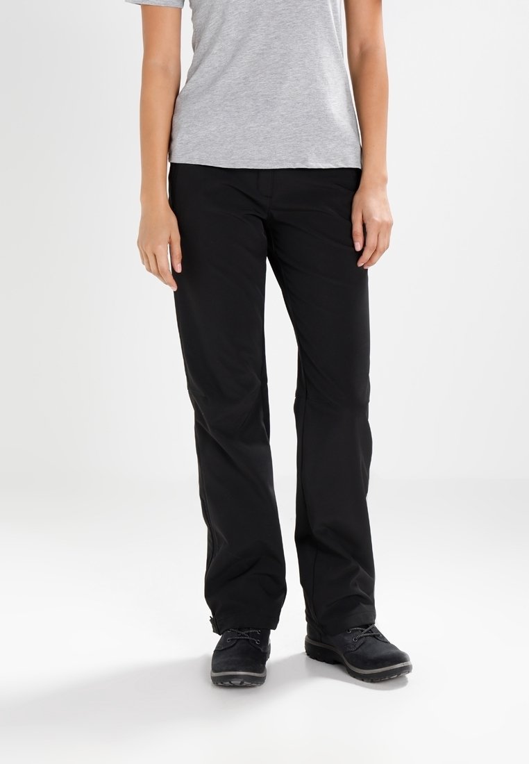 Pantalons noirs, légers, à jambe droite avec une texture lisse, un ajustement sur mesure et une taille sécurisée. Portés avec une chemise grise à manches courtes et des chaussures foncées.