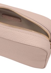 Pochette in pelle rosa chiaro con una finitura testurizzata, dotata di una zip dorata. L'interno presenta una fodera in tessuto liscio e il logo del marchio.