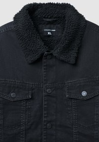 Giacca di jeans nera con colletto in shearling nero testurizzato. Presenta due tasche sul petto con chiusure a bottone e bottoni sul davanti. Tag della taglia XL visibile.