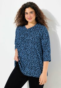 Modrá blůza s vzorem, výstřihem do V a tříčtvrtečními rukávy, s texturou na pevném lehkém materiálu.