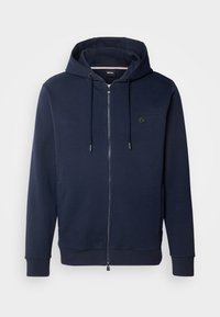Navy blauwe hoodie met rits, een capuchon met trekkoorden, ribgebreide manchetten, zijzakken en een klein logoaccent op de borst. Gemaakt van zachte stof.