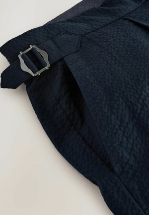 Navy blue fabric shorts with a textured surface, featuring a silver buckle closure and tailored fit, displaying diagonal seam detail.