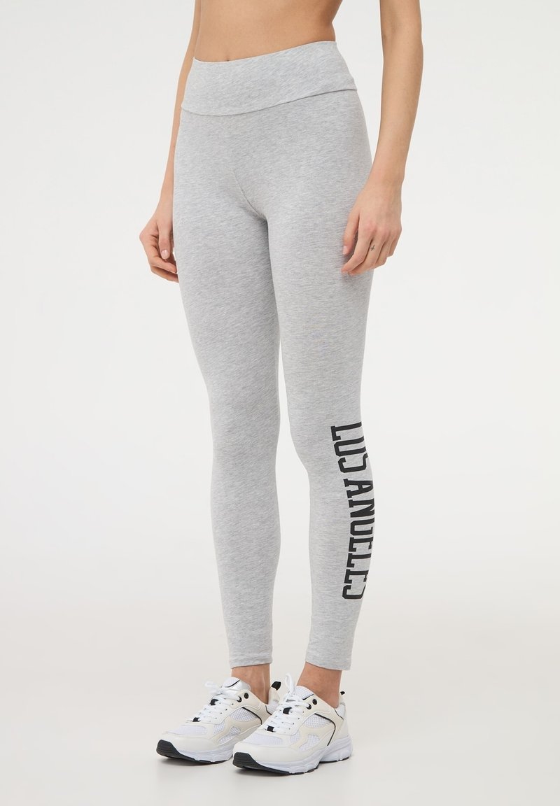 Leggings grigi con vita alta e testo nero "LOS ANGELES" lungo il lato sinistro, realizzati in un materiale morbido e elastico.