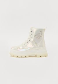 White ankle boots with an iridescent finish, featuring butterfly cutouts, thick white sole, and lace-up design. Textured material and accents.