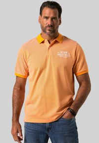 Oranžové polo tričko s kontrastním žlutým límečkem a manžetami. Obsahuje potisk loga v bílé barvě na levé části hrudi. Uvolněný střih.