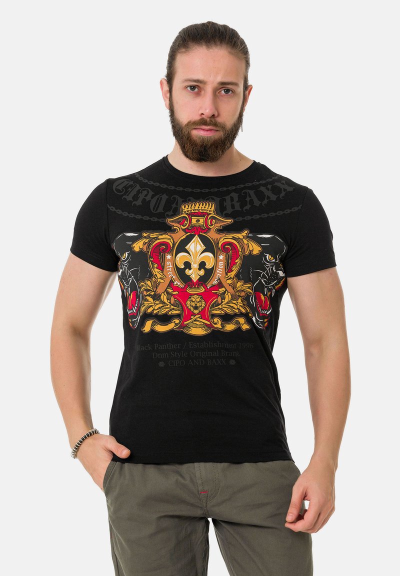 Schwarzes Baumwoll-T-Shirt mit einem bunten Grafikdesign featuring Löwen und verschnörkelten Elementen, kurzen Ärmeln und einer taillierten Form.