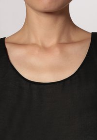Top senza maniche nero con ampia scollatura rotonda, realizzato in tessuto leggero. La texture sembra liscia e leggermente trasparente.
