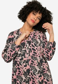Robe à manches longues en imprimé léopard rose, noir et beige avec un décolleté boutonné et une coupe décontractée. Tissu doux et texturé, détails froncés.
