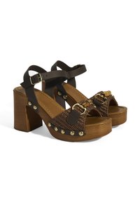 Braune geflochtene Sandalen mit breiten Riemen und einer Schnalle, Holzblockabsatz und goldenen Akzenten entlang der Sohle. Flache Sohle mit Polsterung für zusätzlichen Komfort.