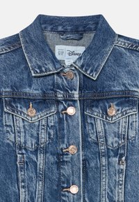 Farmer dzseki kisbab�ák számára, elöl gombos záródással, két gombos mellzsebével és Baby GAP és Disney együttműködést jelző címkével.