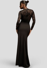 Zwarte zeemeerminnenjurk met een aansluitend silhouet, lange kanten mouwen en een gestructureerd kanten lijfje met een rugsplit en een gladde rok.