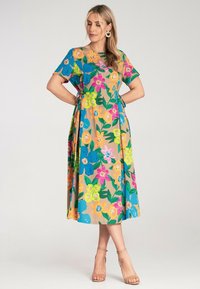 Blumendruckkleid mit kurzen Ärmeln, tailliertem Schnitt und fließender Silhouette in lebendigen Farben wie Blau, Pink, Gelb und Grün.