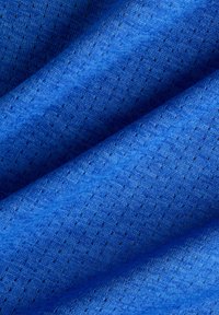 Tissu en bleu vibrant, présentant une surface texturée avec de petites perforations, créant un motif respirant et une finition lisse.