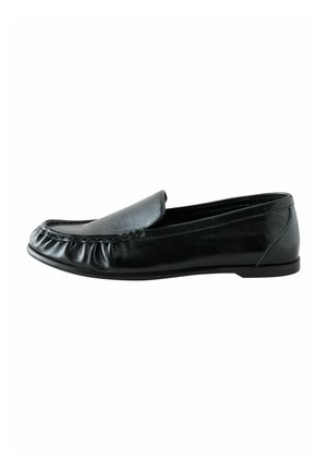 Mocassin noir en cuir à enfiler avec un petit talon et des coutures froncées autour du bord avant, vu de côté.