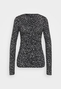 Top à manches longues en noir avec un motif de points irréguliers blancs. Présente un design froncé avec un tissu texturé, une silhouette ajustée et un col rond.