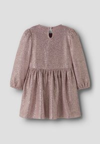 Vestido rosa brillante con mangas largas, tela texturizada, cintura fruncida y cierre en la espalda con un agujero que incluye un pequeño detalle de botón.