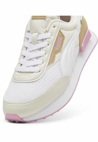 White and beige sneaker with a textured mesh upper, prominent laces, and pink accents on the sole. Features smooth leather details.
