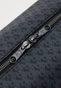 Pouch nera con texture a zip che presenta un sottile motivo leopardato, chiusura a zip con linguette metalliche e bordi cuciti per una maggiore durata.