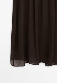 Schwarzer, strukturierter Stoff mit leicht transparenter Qualität. Die Kanten sind sanft gesäumt, und die Oberfläche weist feine vertikale Linien auf.